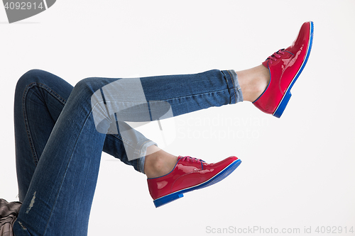 Image of Woman\'s Legs In Blue Jeans And Red Shoes