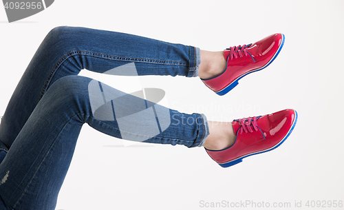 Image of Woman\'s Legs In Blue Jeans And Red Shoes