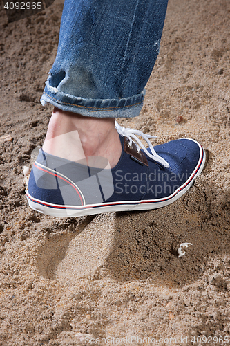 Image of Man\'s Legs And Footprint On The Sand