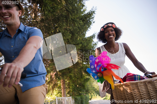 Image of Young multiethnic couple having a bike ride in nature