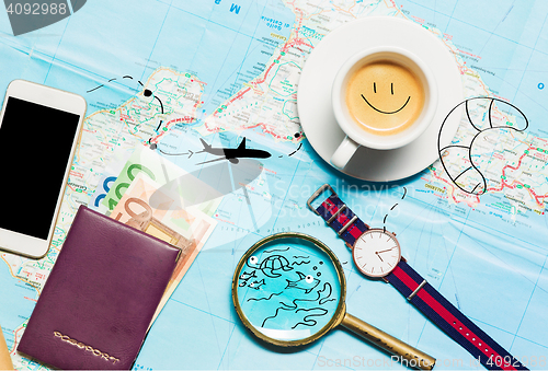 Image of Preparation for travel concept - map, magnifying glass, cup of coffee, notepad, phone