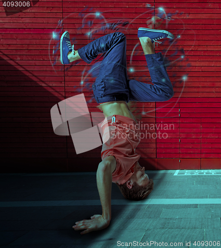 Image of Break dancer doing handstand against colorful wall background