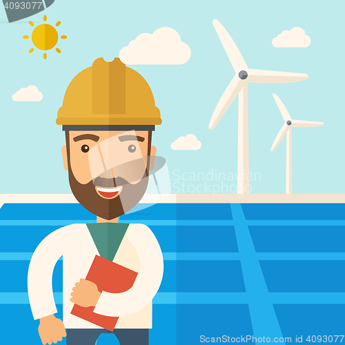 Image of Man in solar panel and windmills.