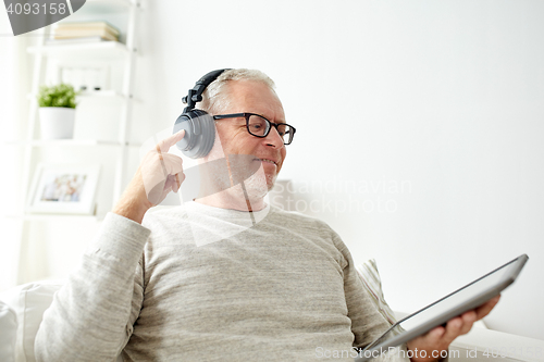 Image of senior man with tablet pc and headphones at home