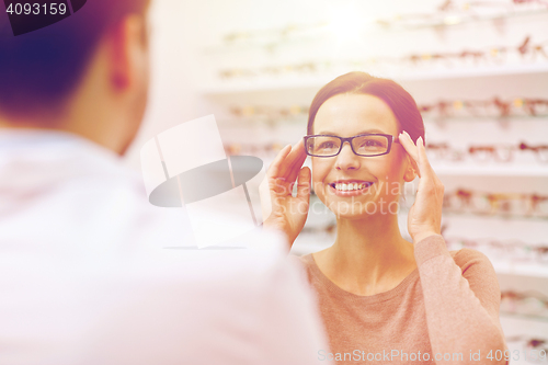 Image of woman showing glasses to optician at optics store