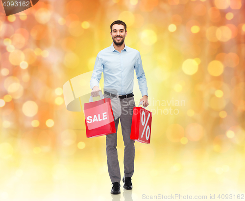 Image of smiling man with red shopping bag