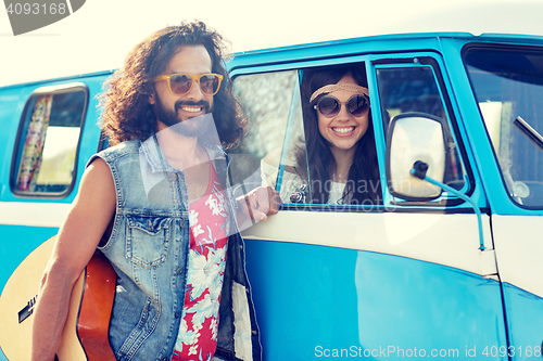 Image of smiling young hippie friends over minivan car