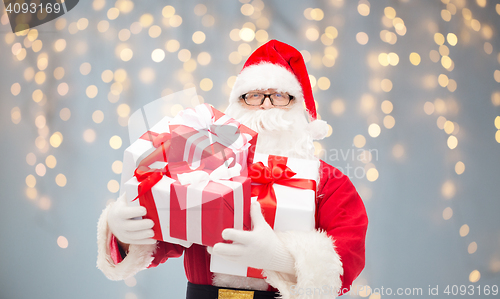 Image of man in costume of santa claus with gift boxes