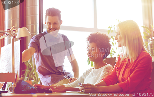 Image of happy creative team with computer in office