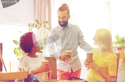 Image of happy creative team drinking coffee in office