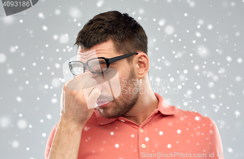 Image of tired man with eyeglasses touching his nose bridge