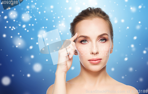 Image of beautiful woman showing her forehead over snow