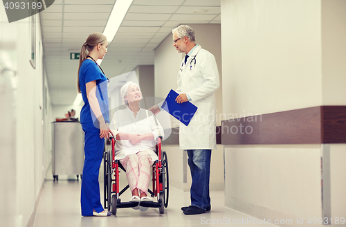 Image of medics and senior woman in wheelchair at hospital