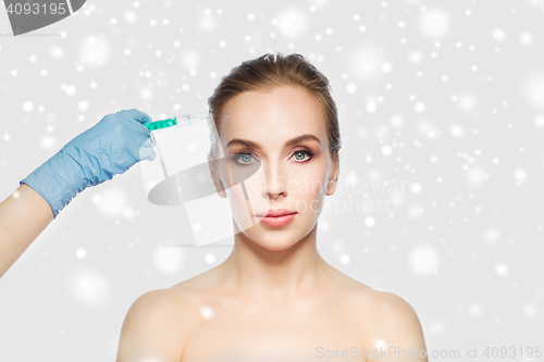 Image of woman face and hand with syringe making injection