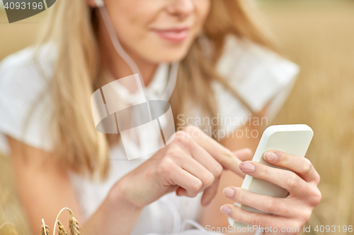 Image of close up of woman with smartphone and earphones