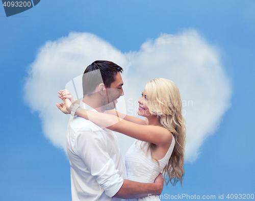 Image of happy couple hugging over heart shaped cloud