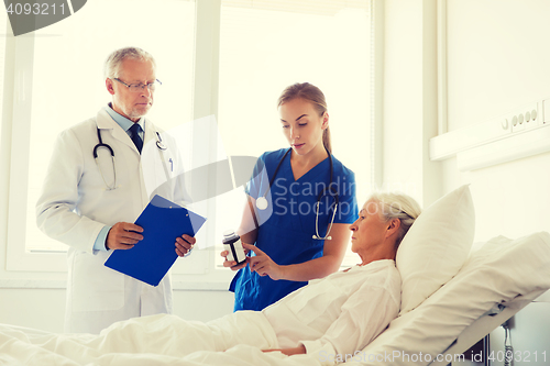 Image of doctor giving medicine to senior woman at hospital