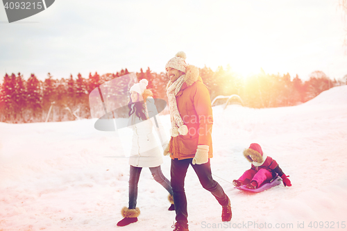 Image of happy family with sled walking in winter outdoors