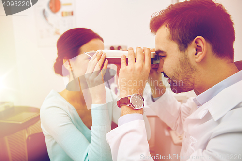 Image of optician with pupilometer and patient at eye clinic