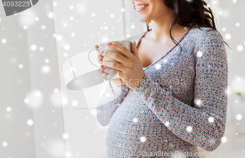 Image of close up of pregnant woman with tea cup at window
