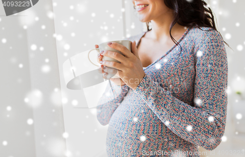 Image of close up of pregnant woman with tea cup at window