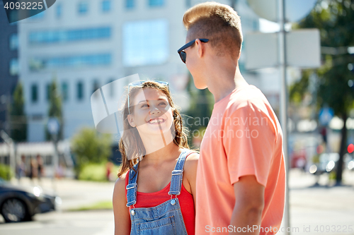 Image of happy teenage couple looking at each other in city