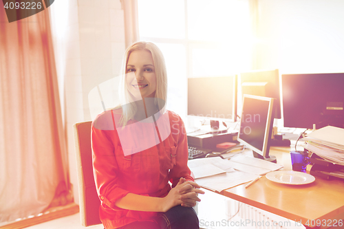 Image of happy creative female office worker with computers