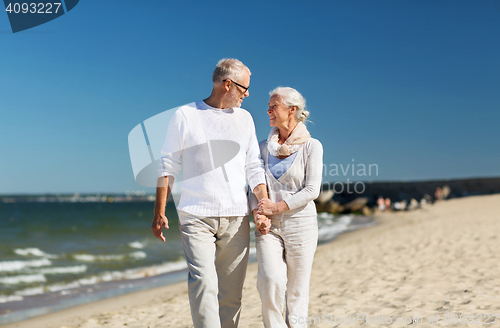 Image of happy senior couple holding hands on summer beach