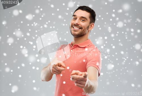 Image of man pointing finger to you over snow background