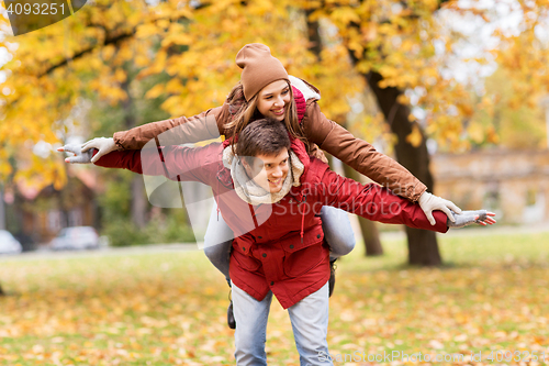 Image of happy young couple having fun in autumn park