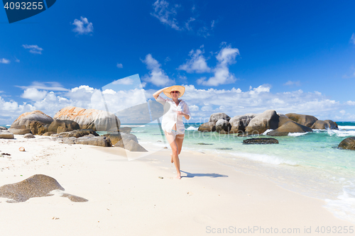 Image of Woman enjoying white sandy beach on Mahe Island, Seychelles.