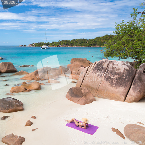 Image of Woman sunbathing at Anse Lazio picture perfect beach on Praslin Island, Seychelles.