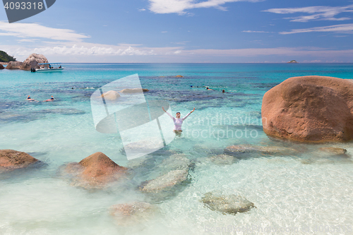 Image of Woman enjoying Anse Lazio picture perfect beach on Praslin Island, Seychelles.