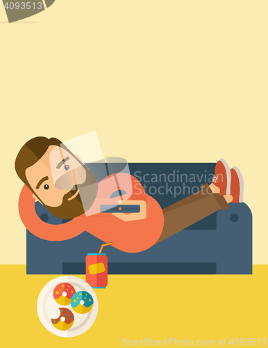 Image of Man lying in the sofa holding a remote.