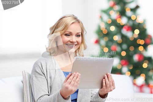 Image of happy woman with tablet pc at christmas