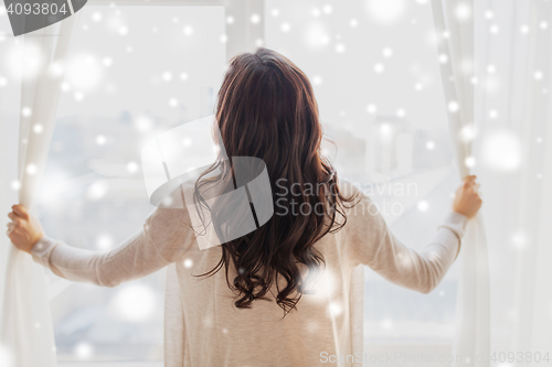 Image of close up of woman opening window curtains