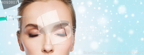 Image of close up of woman face and syringe over snow