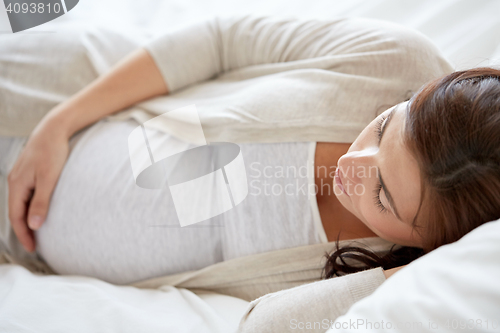 Image of pregnant woman sleeping in bed at home