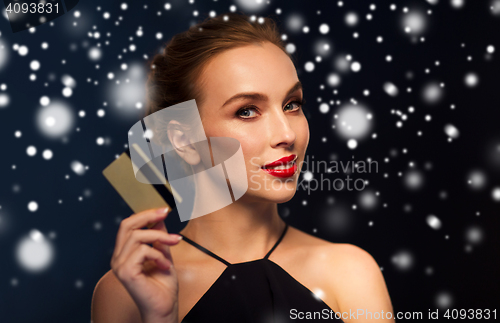 Image of beautiful woman with credit card over snow