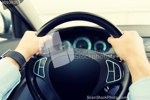 Image of close up of man driving car with computer screen