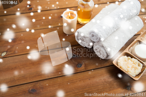 Image of bath towels, candle, massage oil and body scrub