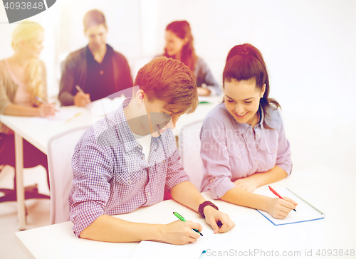 Image of smiling students with notebooks at school