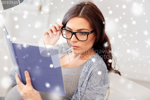 Image of pregnant woman reading book at home