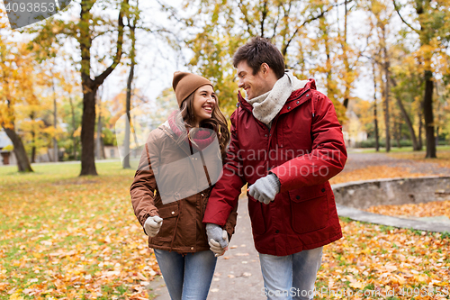 Image of happy young couple walking in autumn park