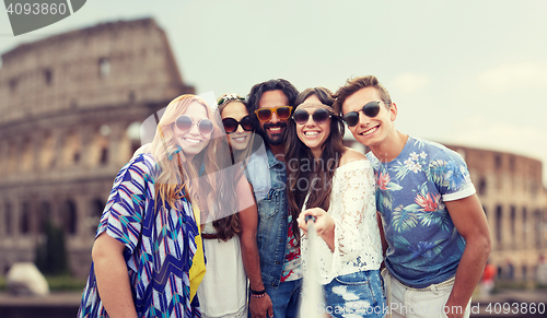 Image of happy hippie friends with selfie stick at coliseum