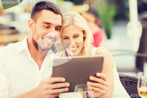Image of happy couple with tablet pc at restaurant lounge