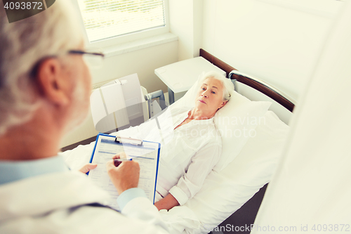 Image of senior woman and doctor with clipboard at hospital