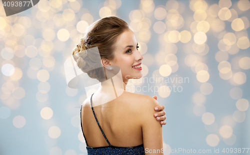 Image of woman in evening dress from back over lights