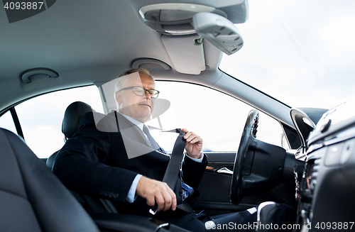 Image of senior businessman fastening car seat belt