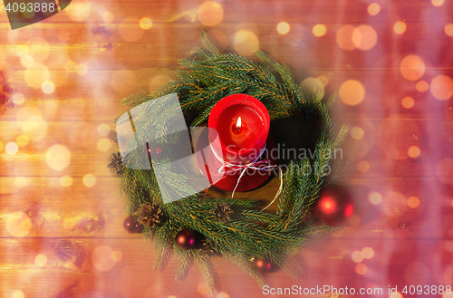 Image of fir branch wreath with candle on wooden table